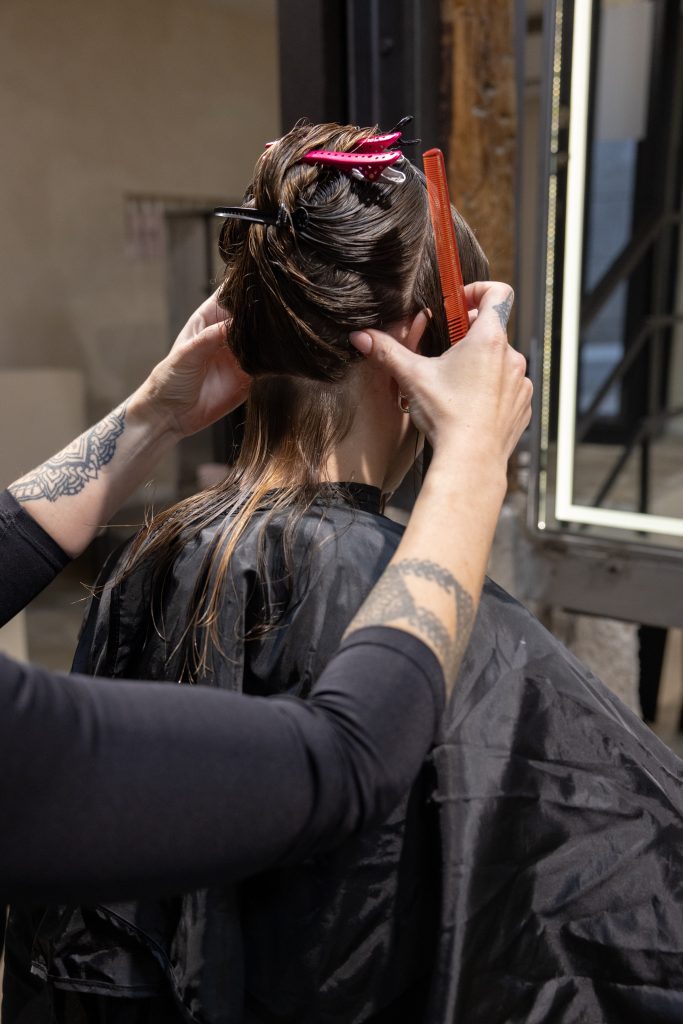 Colorista seccionando el cabello de una clienta en ATICA